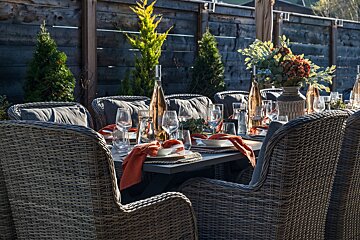 A table set for a dinner party with wicker chairs