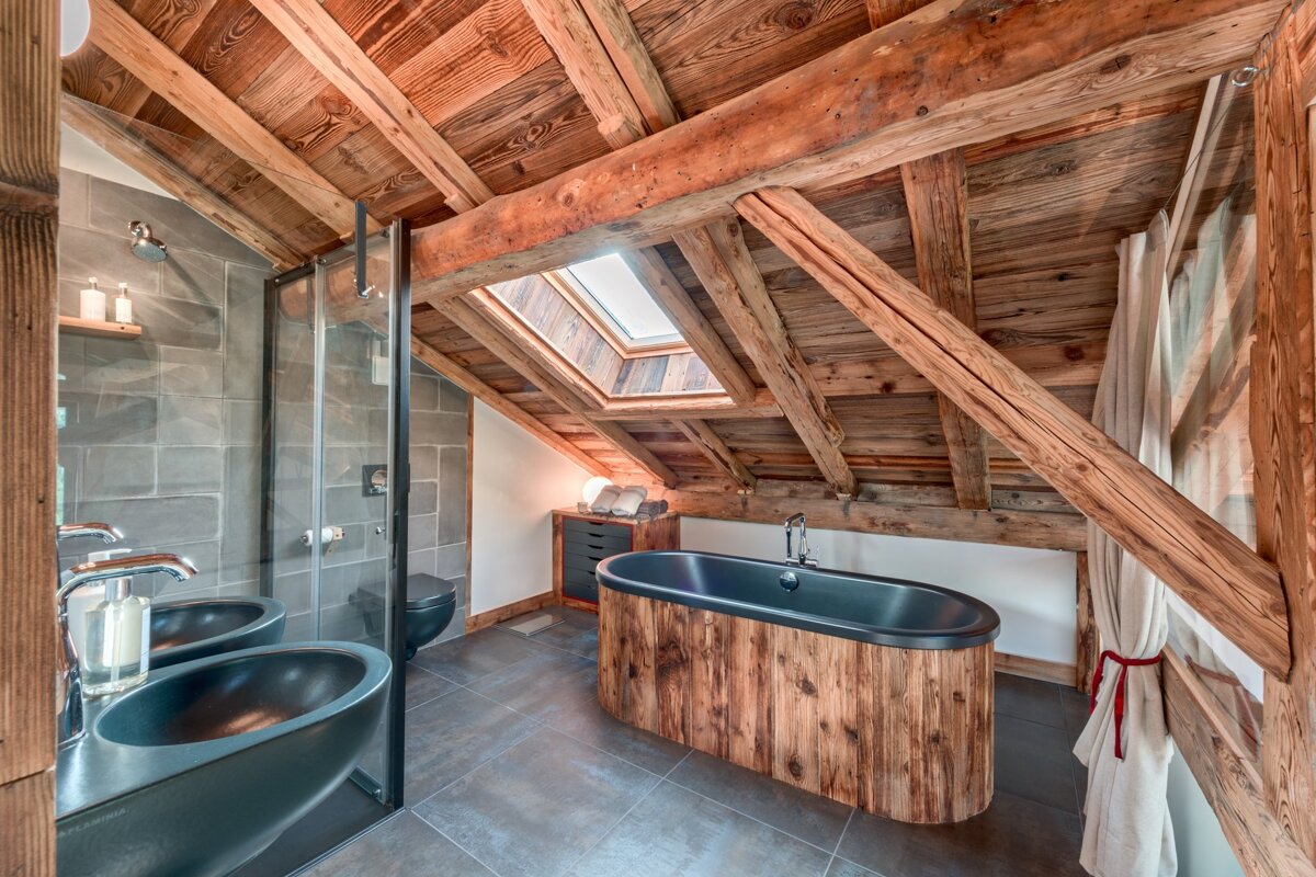 A bathroom with wooden beams and a bathtub
