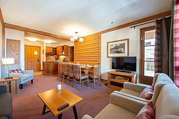 A living room with a table and chairs and a flat screen tv