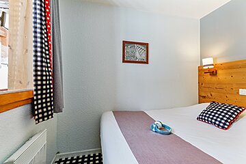 A bedroom with a bed and a picture on the wall