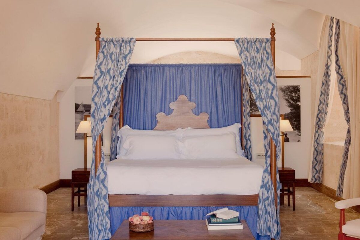 A bed with a blue canopy and white sheets