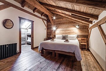 A bedroom with a bed and a mirror on the wall