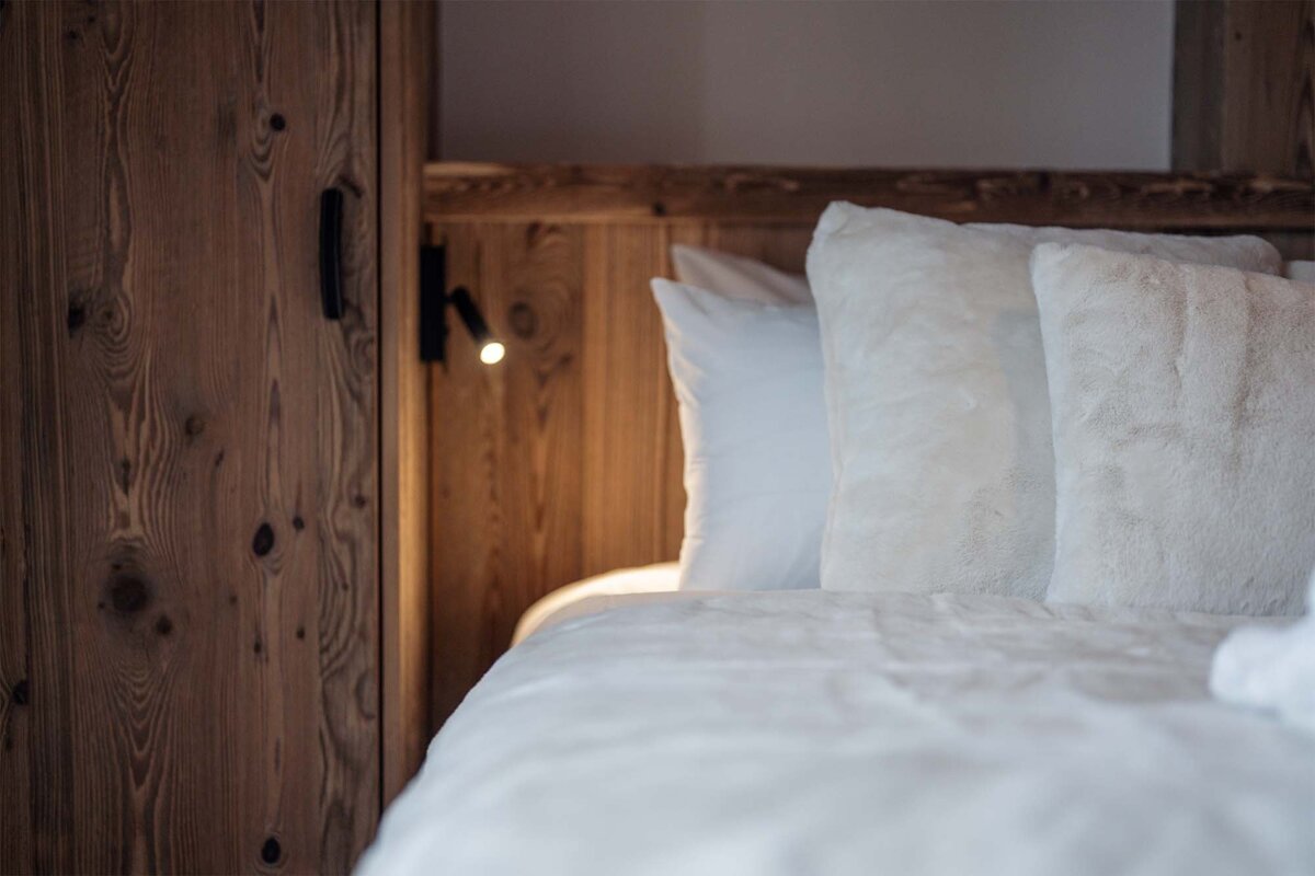 A bed with white pillows and a wooden headboard