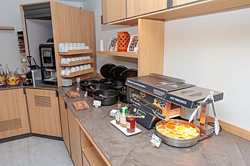 A kitchen counter with a machine that says hot pancakes on it