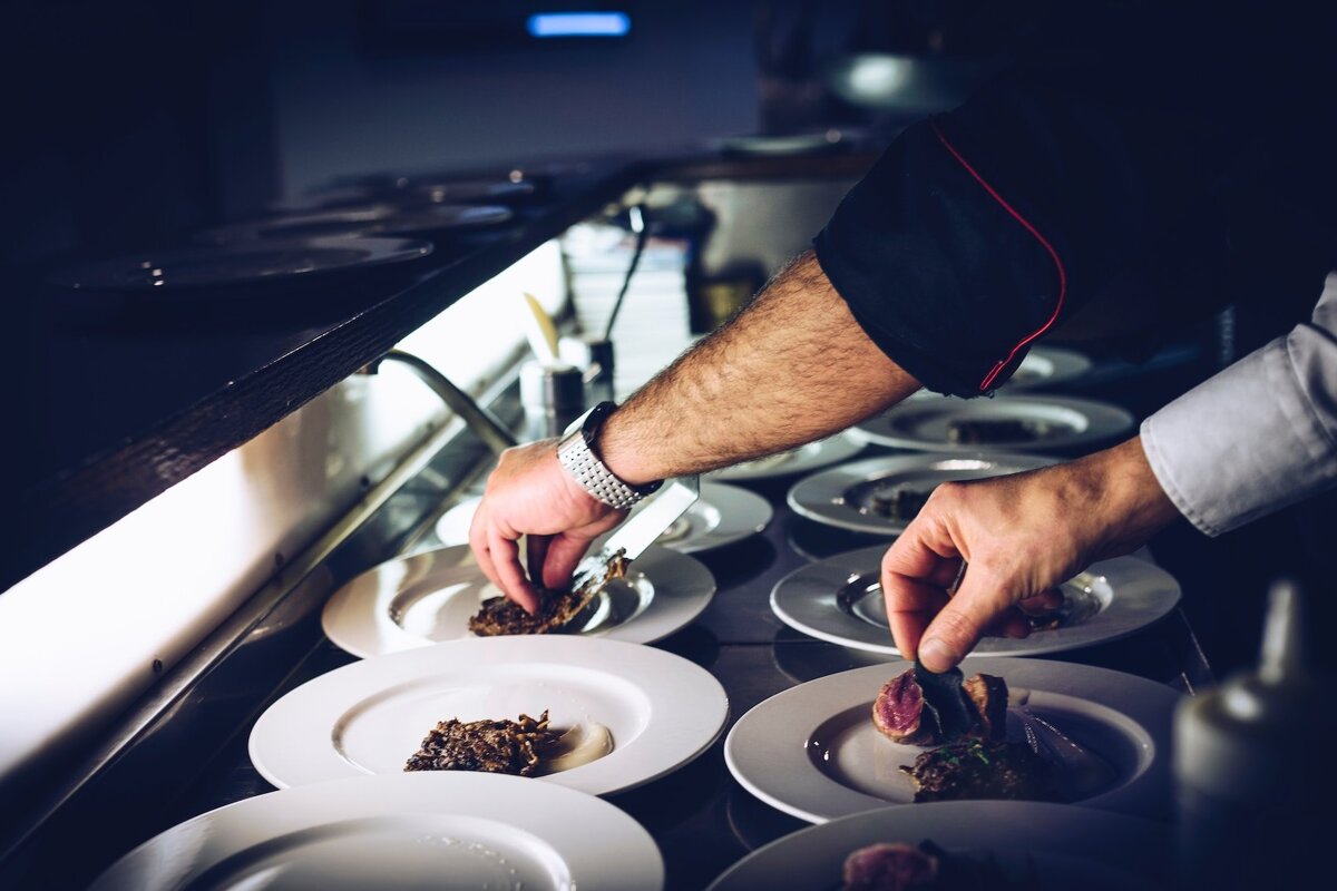 A chef prepares a plate of food in a kitchen