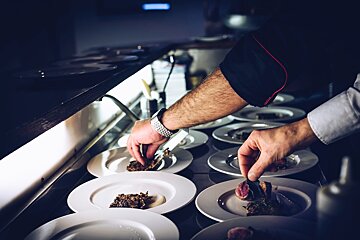 A chef prepares a plate of food in a kitchen