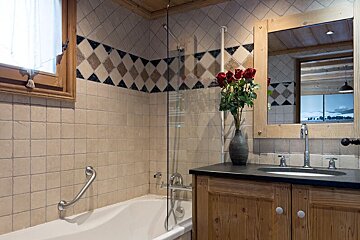 A bathroom with a bathtub sink and mirror