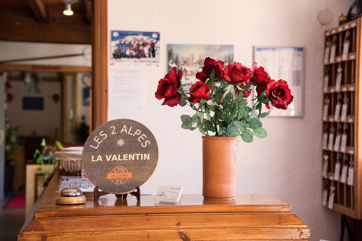 A wooden sign that says les 2 alpes la valentin