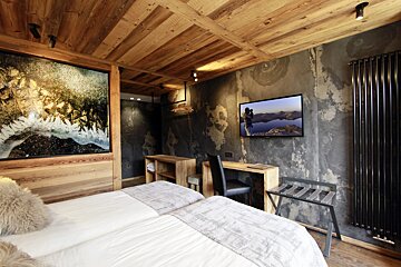 A bedroom with two beds and a flat screen tv