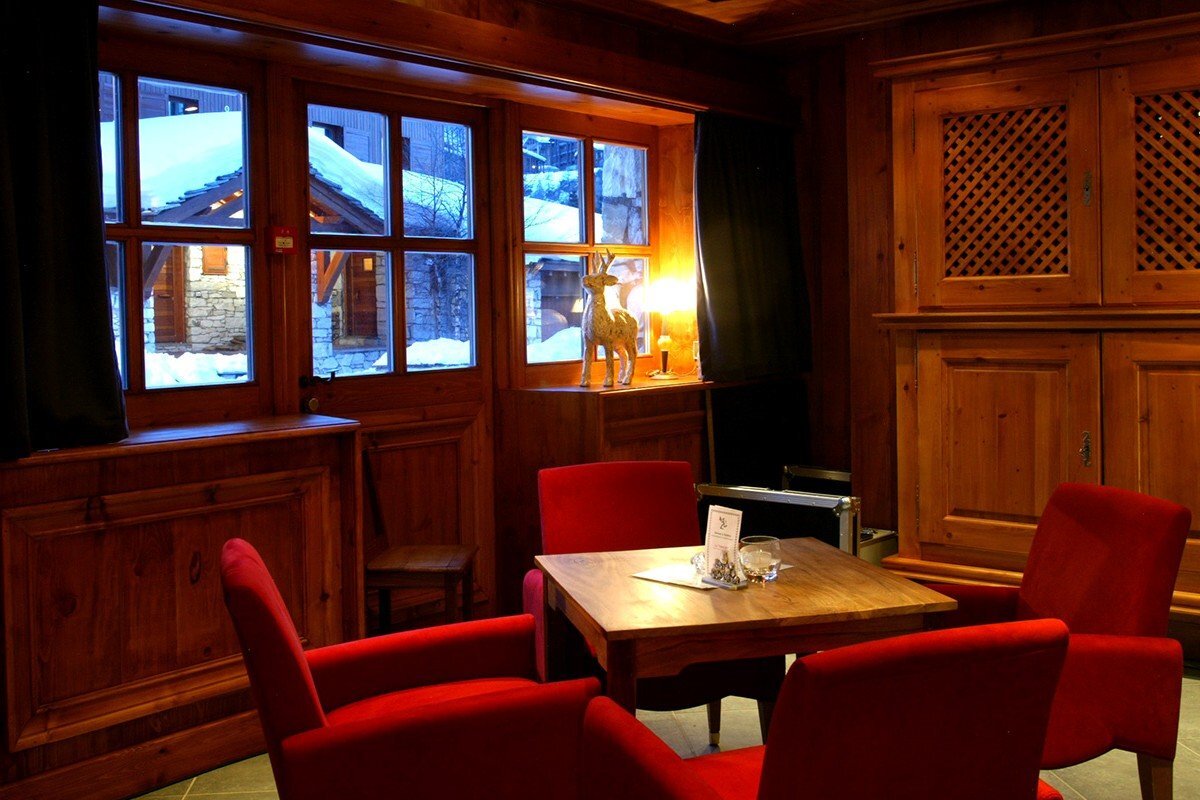 A room with red chairs and a wooden table