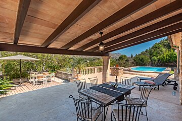 A table and chairs on a patio overlooking a pool