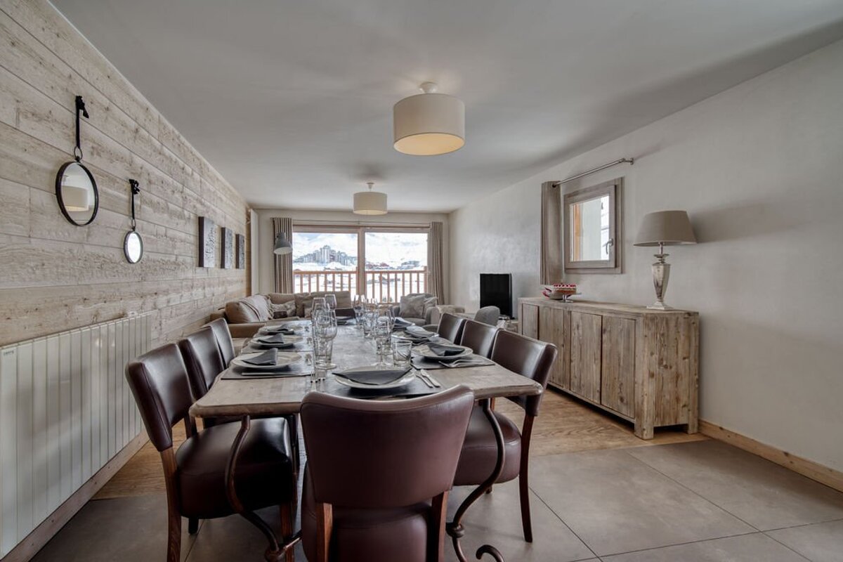 A dining room with a long table and chairs