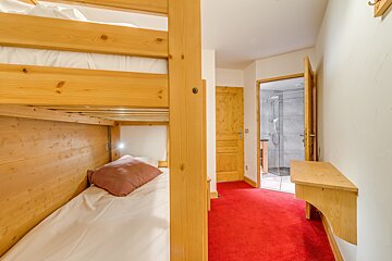A bedroom with bunk beds and a red carpet