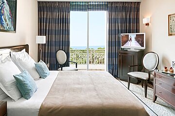 A hotel room with a large bed and a flat screen tv