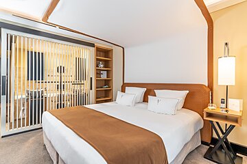 A hotel room with a bed and pillows with the letter v on them