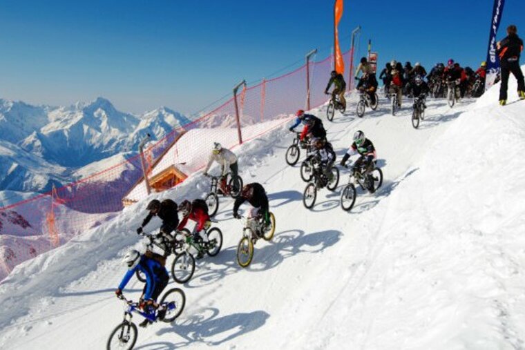 A group of people are riding bikes down a snowy hill
