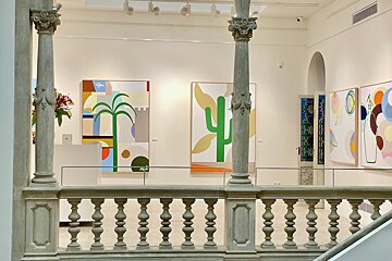 A painting of a cactus is on display in a museum