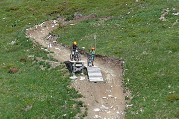 two mountain bikers taking a look at a jump in chamonix