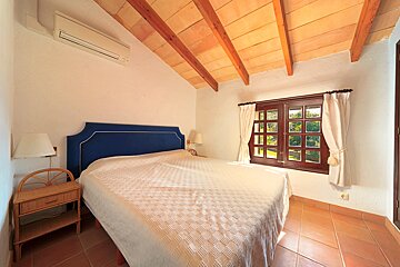 A bedroom with a large bed and a window