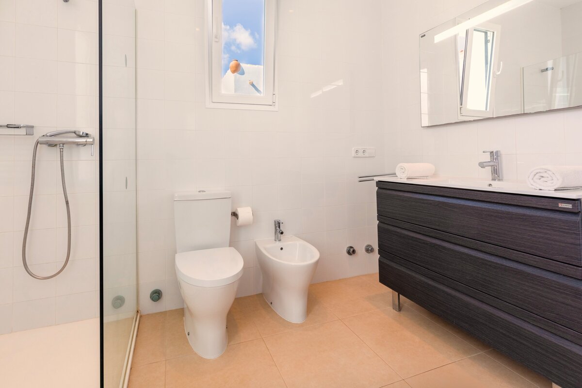 A bathroom with a toilet a bidet and a sink