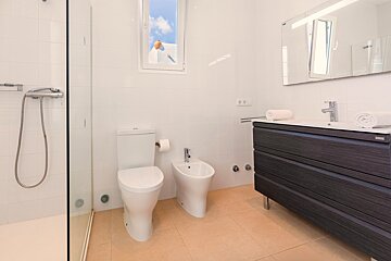 A bathroom with a toilet a bidet and a sink