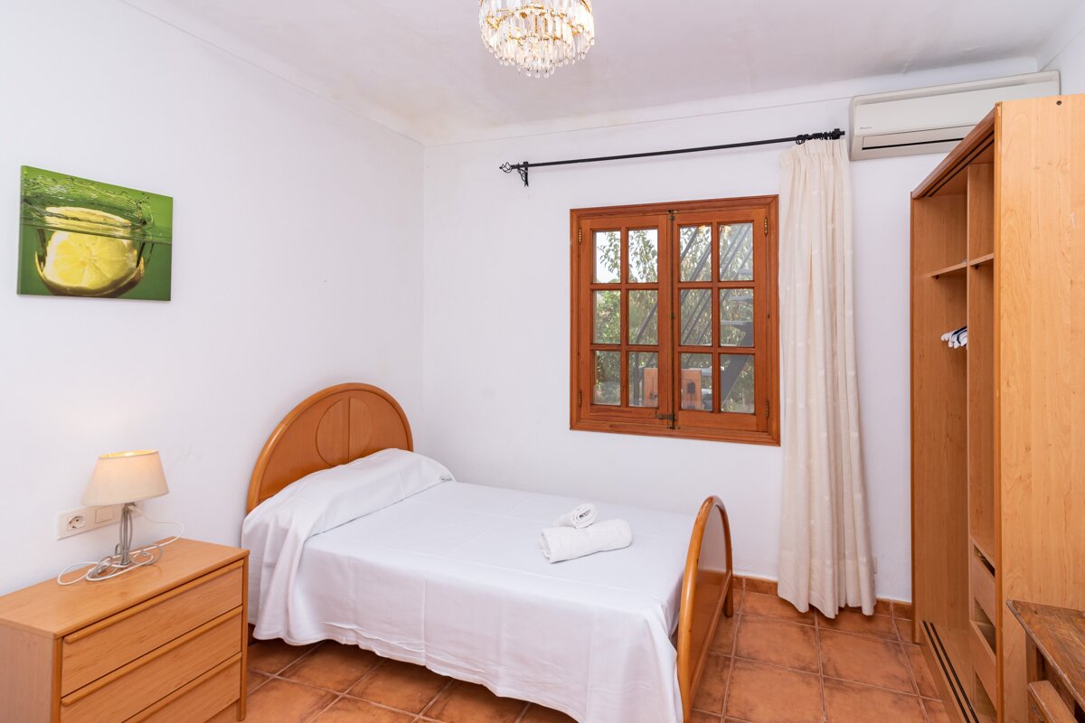 A bedroom with a single bed and a picture of a lemon on the wall
