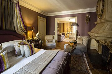 A bedroom with purple walls and a canopy bed