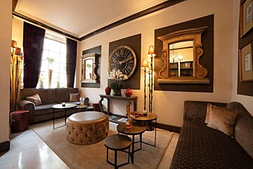 A living room with a couch and a clock on the wall