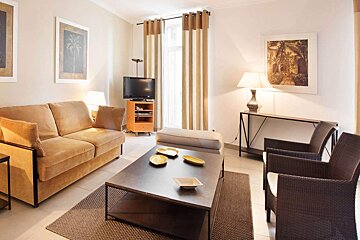 A living room with a couch and two chairs