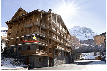 A large building with a yellow star pointing to the apartment