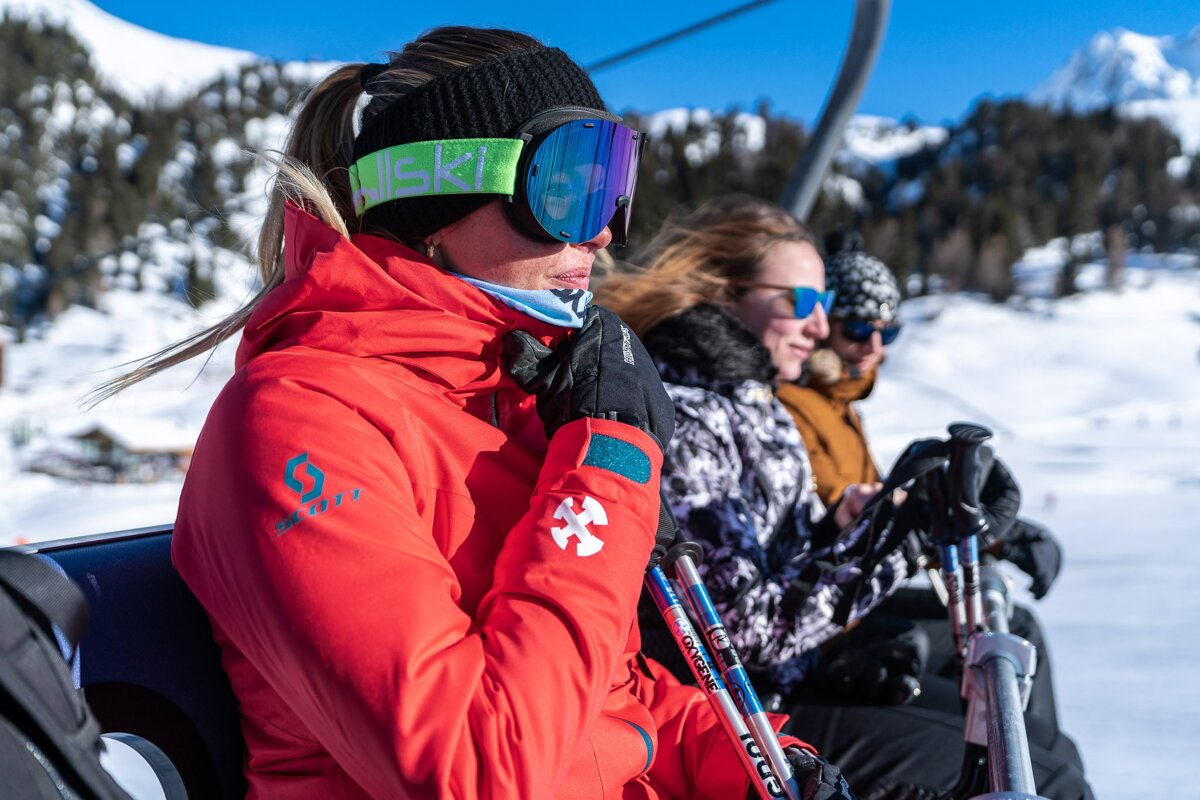 A woman wearing a red jacket with the word ski on it