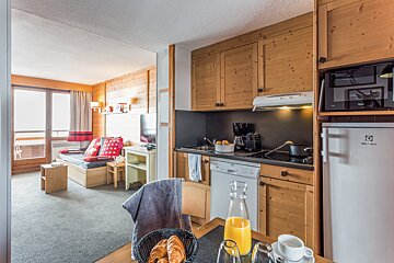 A kitchen with a bottle of orange juice on the table