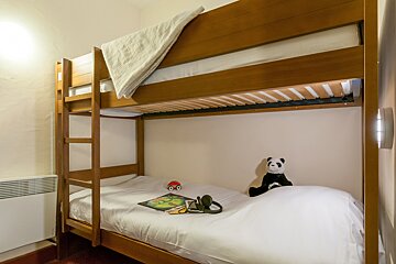 A bunk bed with a stuffed panda on it