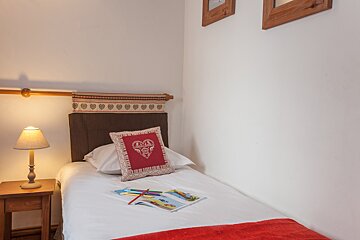 A bed with a pillow that has a heart on it
