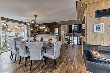A dining room with a table and chairs and a fireplace
