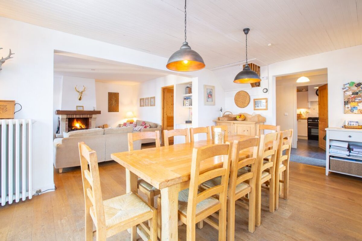 A dining room with a table and chairs and a fireplace
