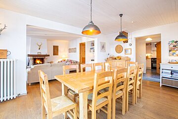 A dining room with a table and chairs and a fireplace