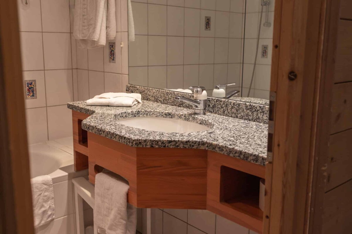 A bathroom with a granite counter top and a sink