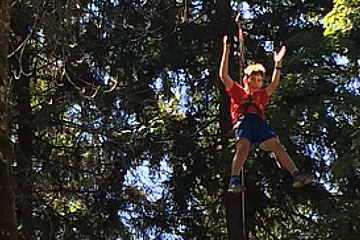 a boy on a treetop rope course