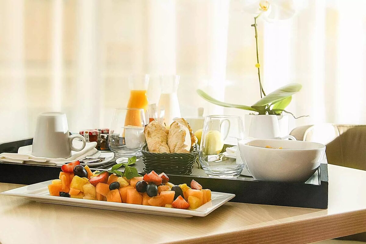 A tray of fruit and bread sits on a table