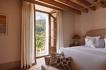 A bedroom with a large bed and a balcony