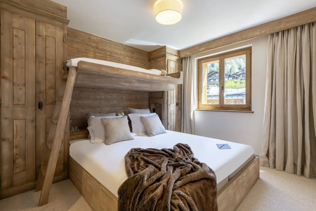A bedroom with a bunk bed and a window