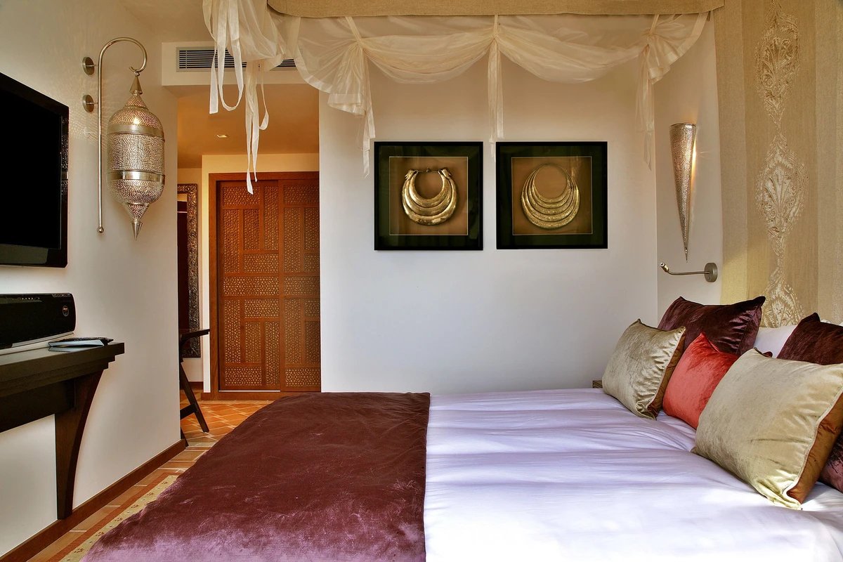A bedroom with a canopy bed and two pictures on the wall