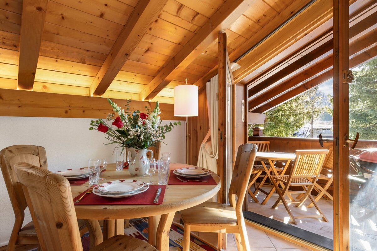 A dining room table with a vase of flowers on it