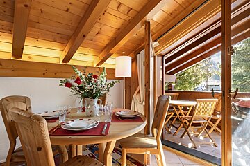 A dining room table with a vase of flowers on it