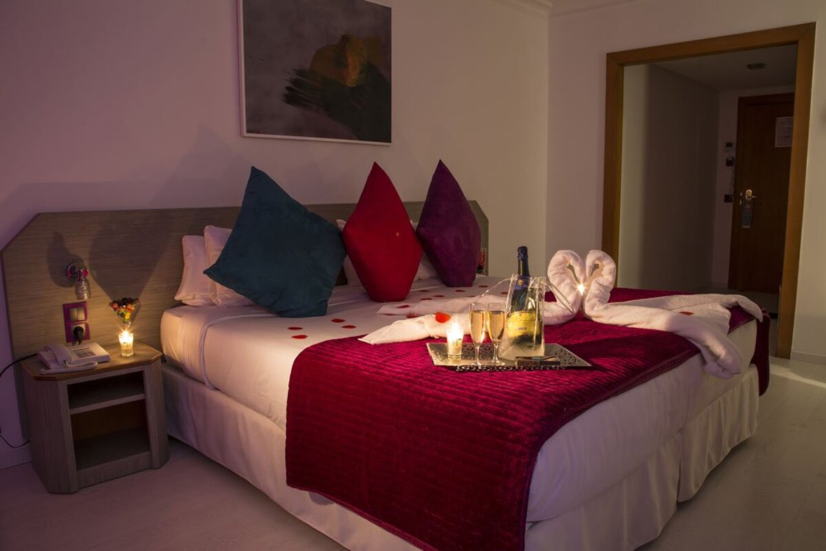 A bed with a bottle of champagne on it