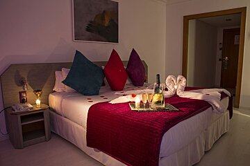 A bed with a bottle of champagne on it