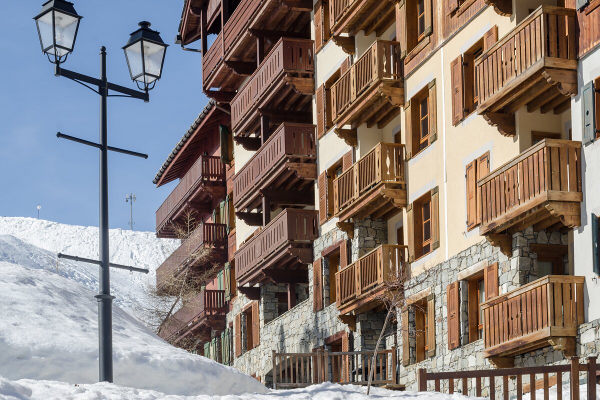 A building with wooden balconies and shutters on the windows