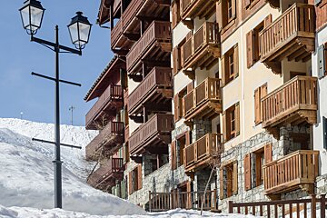A building with wooden balconies and shutters on the windows