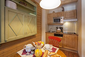 A kitchen with wooden cabinets and a microwave